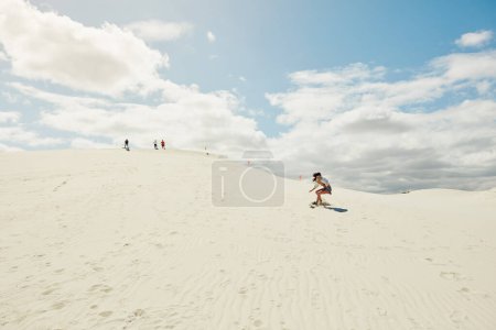 Téléchargez les photos : Sur les dunes, il n'y a pas de zone de confort. une jeune femme planche de sable dans le désert - en image libre de droit