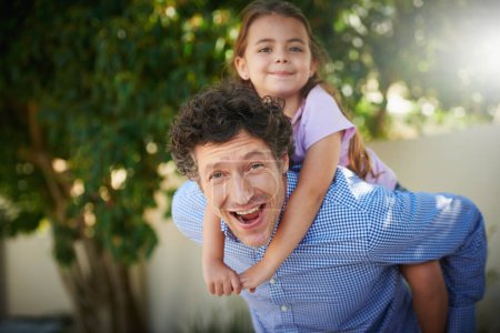 Photo for Family life is never dull around here. Portrait of a father giving his daughter a piggyback ride outside - Royalty Free Image