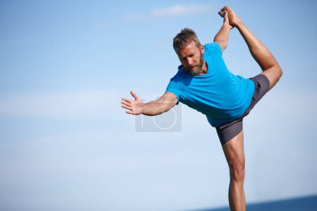 Téléchargez les photos : Il faut beaucoup de concentration. un bel homme mature qui fait du yoga à l'extérieur - en image libre de droit