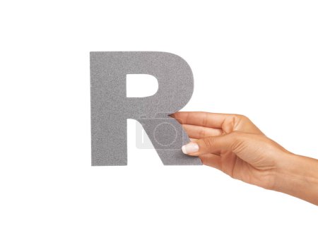 Foto de La letra R. Una joven con una letra mayúscula R aislada sobre un fondo blanco - Imagen libre de derechos