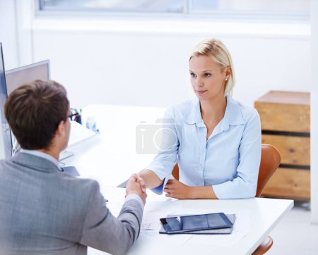 Photo for Now we see eye to eye. a serious businesswoman shaking hands with a male colleague - Royalty Free Image