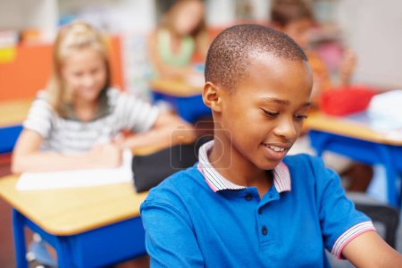 Photo for We all want the best for our kids - Education Funds. Young african-american boy concentrating on his work in class - copyspace - Royalty Free Image