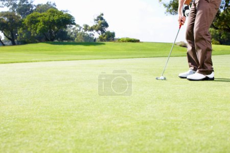Foto de Hombre golfista poniendo la pelota. Sección baja del golfista en posición para poner la pelota - Imagen libre de derechos