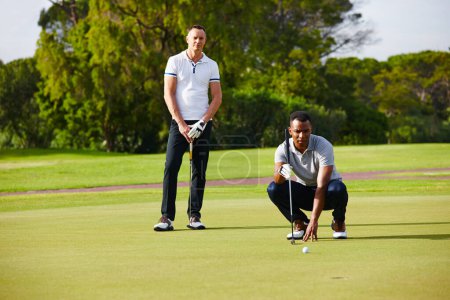 Foto de Golf no es para los débiles de corazón. dos golfistas mirando como la pelota se acerca al agujero - Imagen libre de derechos