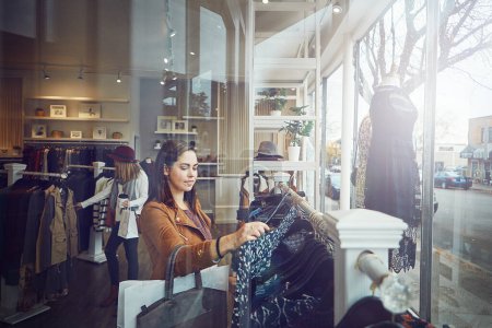 Photo for Maybe I should try something different. a young woman shopping at a clothing store - Royalty Free Image