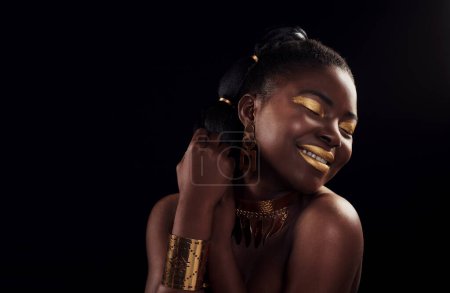 Photo for Beauty, gold and black woman in studio for makeup, art and elegance against a black background. Rich, creative and African female model pose with jewelry for wealth, royal and luxury queen aesthetic. - Royalty Free Image