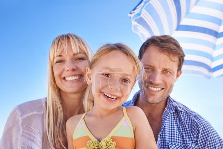 Téléchargez les photos : Vacances près de la plage a ses avantages. Portrait d'une jeune famille heureuse à la plage - en image libre de droit