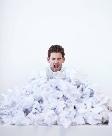 Photo for Argh This is too much. A young businessman looking frustrated while buried in a pile of papers - Royalty Free Image