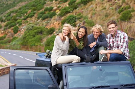 Foto de Vaya, mira eso. un grupo joven de amigos en el techo de su coche - Imagen libre de derechos