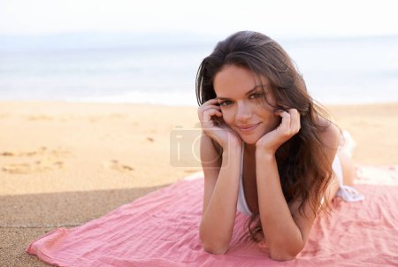 Sommerverliebt. Porträt einer schönen jungen Frau, die am Strand liegt