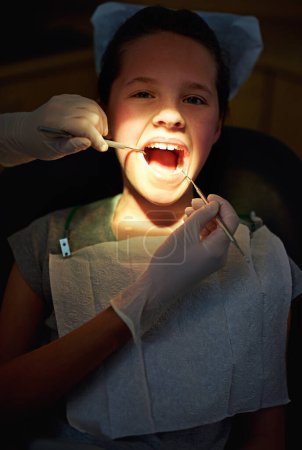 Foto de Echemos un vistazo. Primer plano de una joven que se somete a un chequeo en el dentista - Imagen libre de derechos