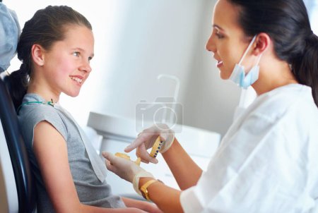 Foto de Debes estar seguro de cepillarte aquí. una dentista y un niño en un consultorio dental - Imagen libre de derechos