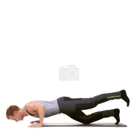 Photo for It takes a lot of strength to perfect this. A fit young man working out on his exercise mat while isolated on white - Royalty Free Image