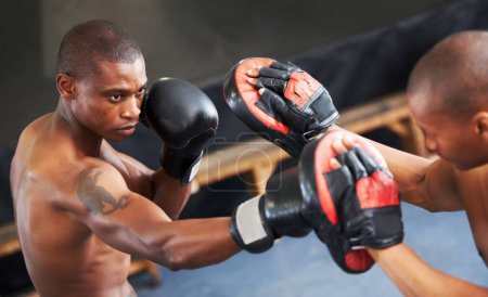 Foto de Motivándonos mutuamente. Un joven boxeador enfocado que lucha con su compañero en guantes protectores - Imagen libre de derechos