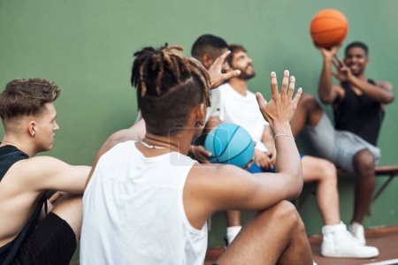 Téléchargez les photos : Le basket-ball est un excellent sport de team building. un groupe de jeunes hommes sportifs traînant sur un terrain de basket - en image libre de droit