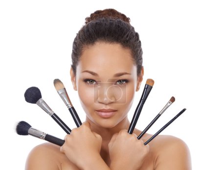 Photo for From big to small. Beauty portrait of a young woman holding up make-up brushes - Royalty Free Image