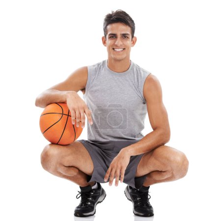 Téléchargez les photos : C'était un bon match. Portrait d'un beau jeune sportif accroupi avec une balle de basket sous son bras - en image libre de droit