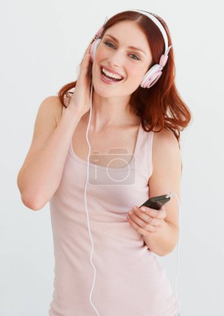 Photo for Woman, headphones and smile in portrait for music, streaming and happiness by wall background. Girl, student or isolated model with smartphone for audio app, sound and internet radio with listening. - Royalty Free Image
