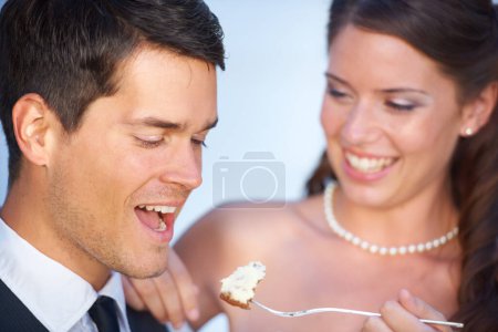 Téléchargez les photos : C'est délicieux. une jeune mariée nourrissant son nouveau mari gâteau de mariage - en image libre de droit