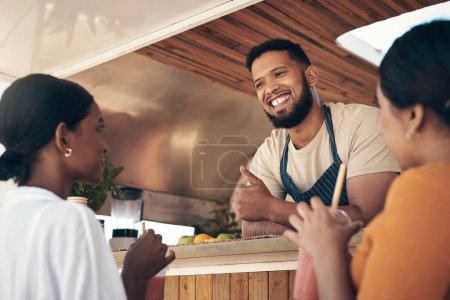 Foto de Espero que tengas un gran día. dos amigos hablando con el dueño de un camión de comida mientras compran batidos - Imagen libre de derechos