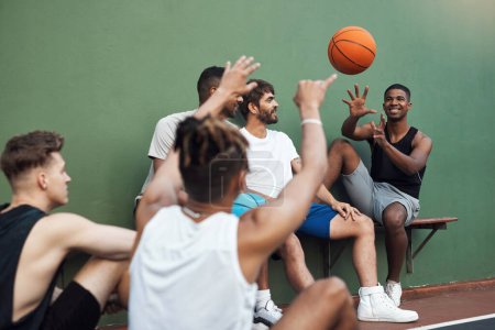 Téléchargez les photos : Passe-le-moi. un groupe de jeunes hommes sportifs traînant sur un terrain de basket - en image libre de droit