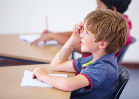 Photo for Listening with rapt attention. A young boy sitting in his seat during class - Royalty Free Image