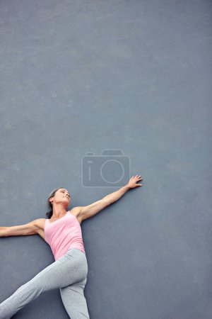 Photo for Stretching her way to relaxation. High angle shot of an attractive mature woman doing yoga outdoors - Royalty Free Image