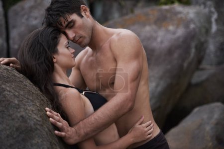 Foto de Atracción fatal. una pareja joven y cariñosa en la playa - Imagen libre de derechos