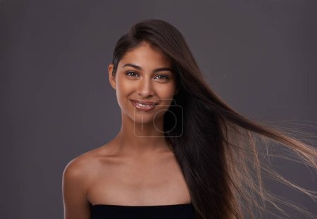 Photo for Letting her natural beauty shine. Portrait of an attractive young woman with windswept hair in studio - Royalty Free Image