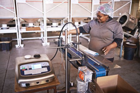 Téléchargez les photos : Sur la ligne de production. une femme travaillant dans un entrepôt d'emballage et de distribution - en image libre de droit