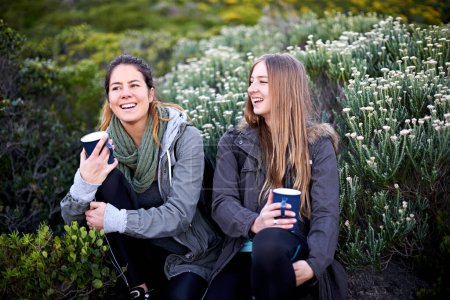 Photo for Mountainside laughter. two attractive young women enjoying hot drinks while out hiking - Royalty Free Image