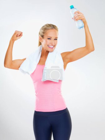 Foto de Compruébalos. Estudio de una atractiva joven vestida con ropa de ejercicio sobre un fondo gris - Imagen libre de derechos