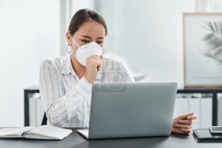 Photo for In self quarantine and still staying productive. a masked young businesswoman coughing while working at her desk in a modern office - Royalty Free Image