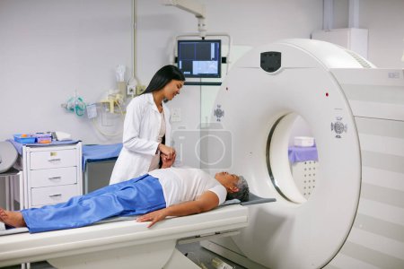 Téléchargez les photos : Docteur, IRM et femme tenant la main du patient à l'hôpital avant de scanner dans la machine. scan Ct, confort et professionnel de la santé avec la personne âgée de sexe féminin dans le test de radiologie pour les soins de santé en clinique - en image libre de droit