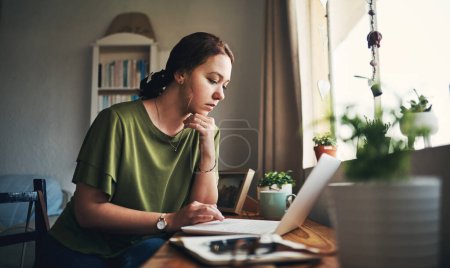 Staying at home, slaying those goals. a young woman using a laptop while working from home