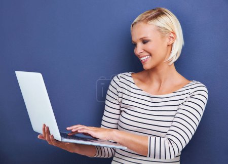 Foto de Es nueva en la blogósfera. Captura de estudio de una joven atractiva usando una computadora portátil - Imagen libre de derechos