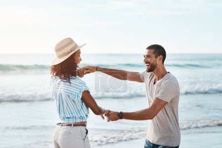 Photo for I just want you to be completely carefree with me. a young couple dancing together at the beach - Royalty Free Image