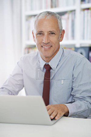 Téléchargez les photos : Grandir est une affaire en ligne. Portrait d'un homme d'affaires mature travaillant sur un ordinateur portable - en image libre de droit