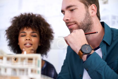 Photo for Bright young architects. two young architects working on a model of a building - Royalty Free Image