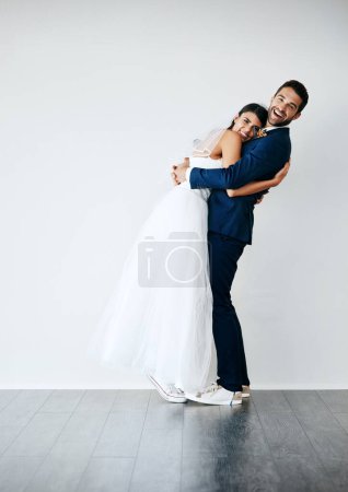 Photo for Im so glad youre shorter than me. Studio shot of a newlywed couple standing against a gray background - Royalty Free Image