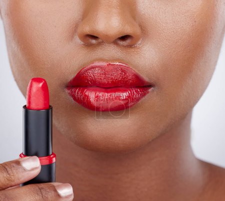 Photo for Lipstick junkie. Cropped studio shot of an unrecognizable woman wearing bright red lipstick against a grey background - Royalty Free Image