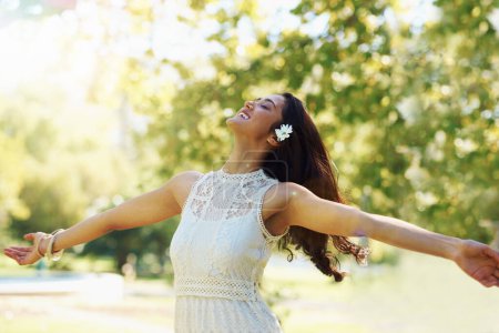 Foto de Free your spirit in the spring air. A young woman twirling in a park with her arms outstretched - Imagen libre de derechos