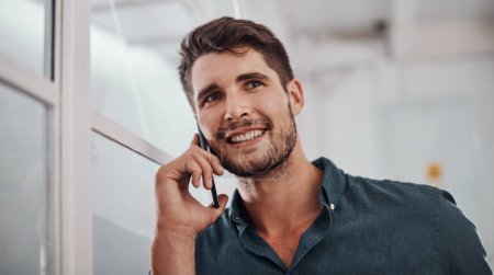 Photo for Yes, I have a moment to talk. a young businessman talking on a cellphone in an office - Royalty Free Image