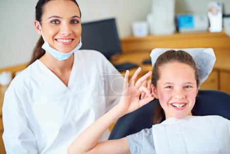 Téléchargez les photos : Un autre bilan parfait. Portrait d'une jeune fille assise dans une chaise de dentiste donnant un signe ok - en image libre de droit