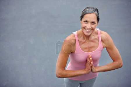 Téléchargez les photos : C'est mon yoga secret du matin. Portrait grand angle d'une jolie femme mature qui fait du yoga à l'extérieur - en image libre de droit