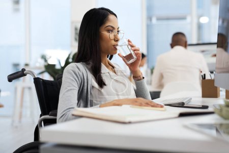 Photo for Staying hydrated through the workday. an attractive young businesswoman drinking water while working at her desk in the office - Royalty Free Image