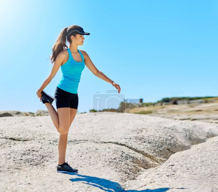 Photo for Make sure to warm up first. a young woman stretching before her run - Royalty Free Image