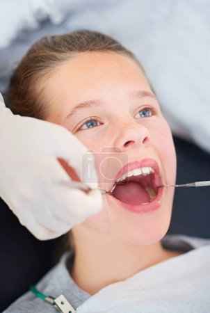 Photo for Her day at the dentist. Closeup shot of a young girl having a checkup at the dentist - Royalty Free Image