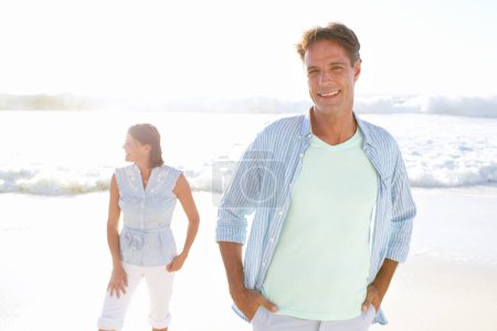Photo for Active and healthy. A handsome mature man enjoying a walk on the beach with his wife - Royalty Free Image