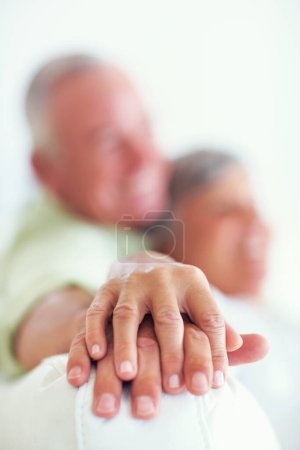 Photo for Bond of love. Loving mature couple relaxing on couch with focus on their hands over lapsed - Royalty Free Image